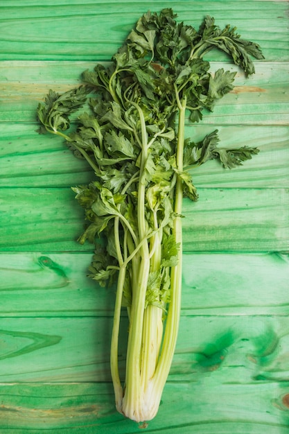 Foto gratuito primo piano di sedano fresco su fondo di legno verde