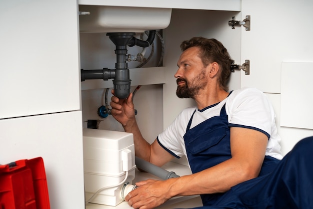 Foto gratuito professionista idraulico che fa il suo lavoro