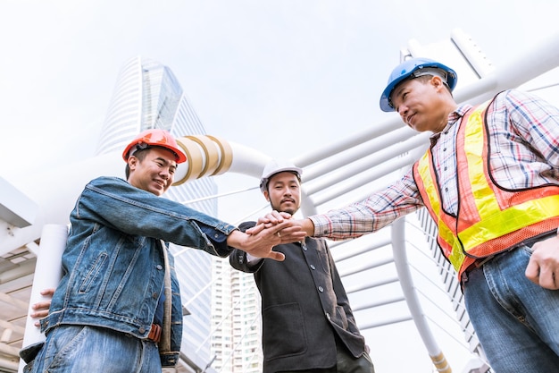 Foto gratuito riunione del manager con l'ingegnere presso la mano dello stack del sito all'aperto per il lavoro di squadra