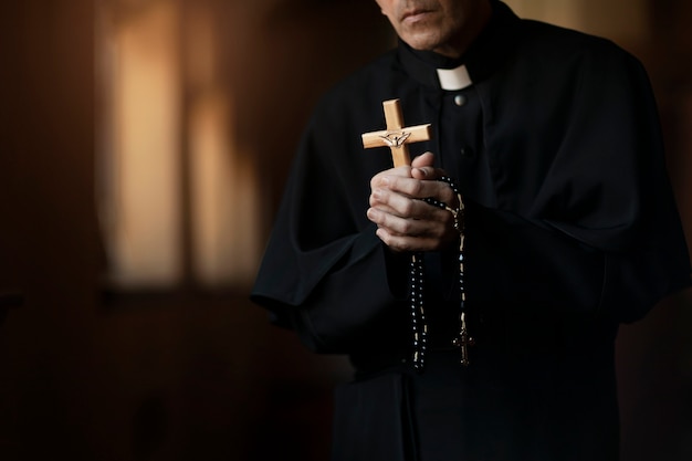 Foto gratuito sacerdote che prega in chiesa