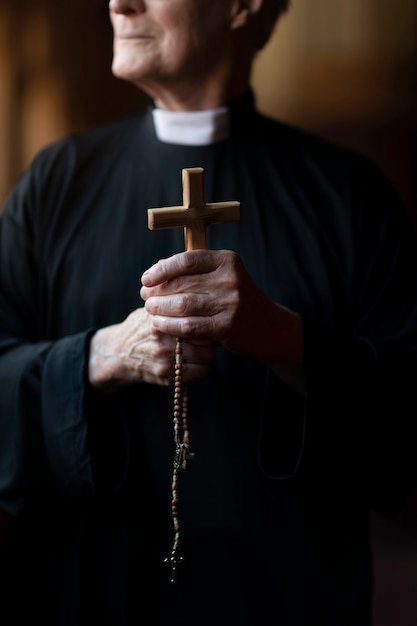 Foto gratuito sacerdote che prega in chiesa