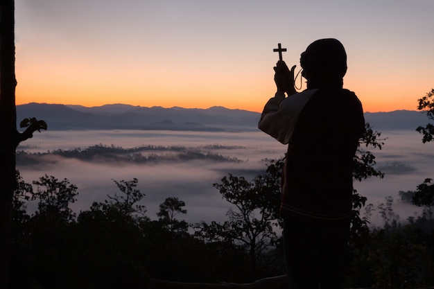 Foto gratuito silhouette della mano umana che tiene la croce, lo sfondo è l'alba