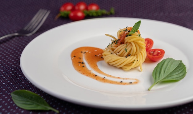 Foto gratuito spaghetti in padella splendidamente disposti in un piatto bianco.