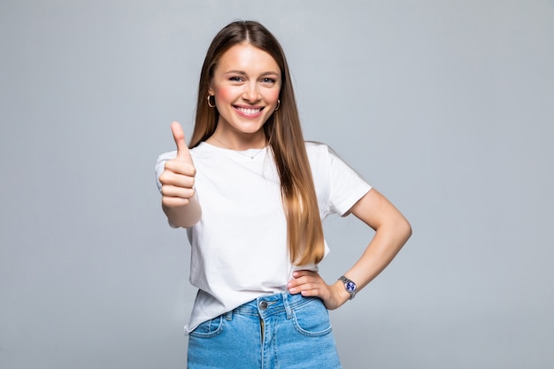 Studente di college femminile felice che mostra i pollici in su isolati