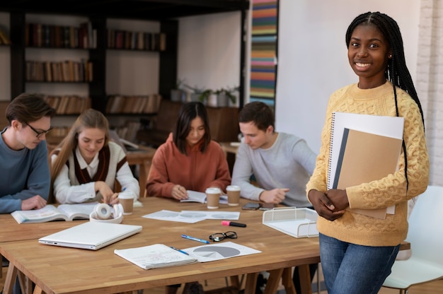 Studente in posa durante una sessione di studio di gruppo con i colleghi