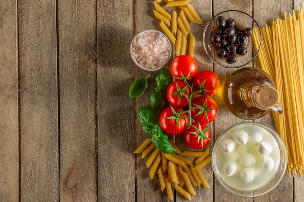 Foto gratuito superficie di legno con gli ingredienti per cottura della pasta