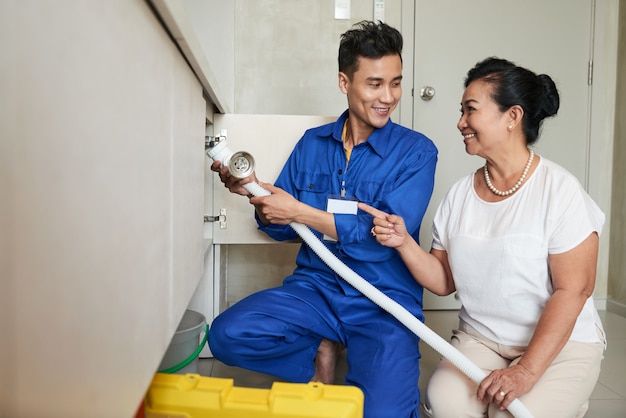 Foto gratuito tuttofare che aiuta donna senior in cucina