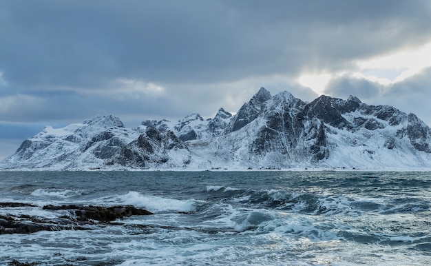 Un bel colpo di onde del mare con una montagna innevata sullo sfondo