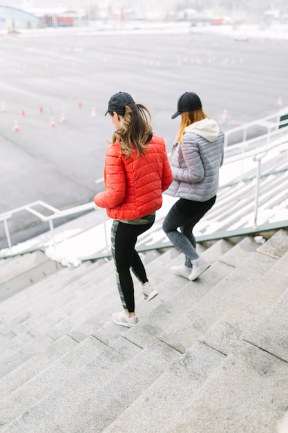 Foto gratuito un pareggiatore femminile due che funziona sulla scala in inverno