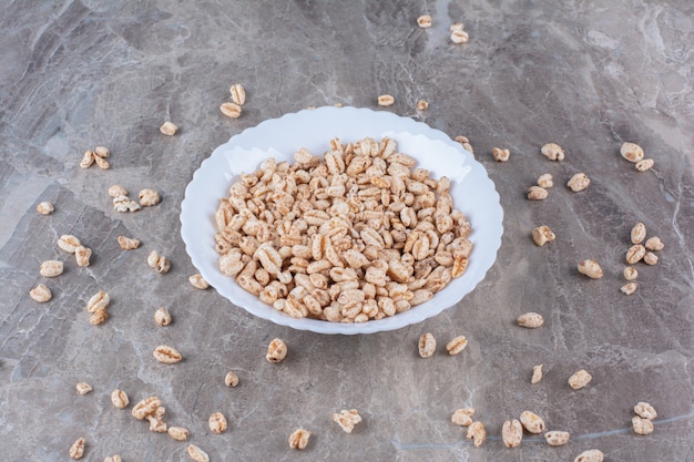 Foto gratuito un piatto bianco pieno di cereali per la colazione a base di riso croccante.