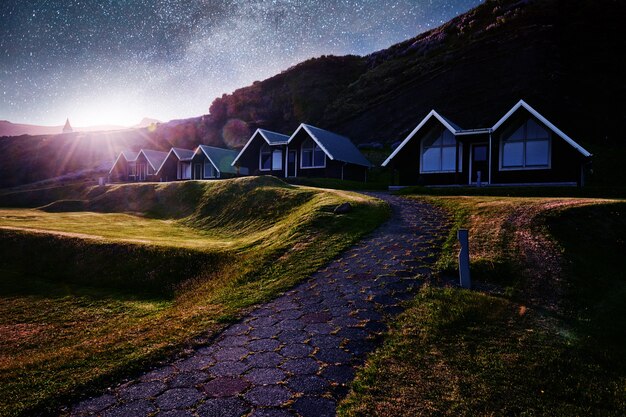 Una piccola chiesa in legno e cimitero Hofskirkja Hof, Skaftafell Islanda. Tramonto scenico attraverso corone d'albero