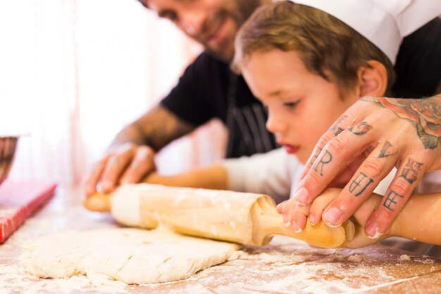 Uomo che impasta la pasta con il figlio