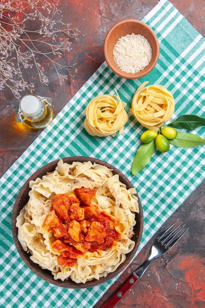 Foto gratuito vista dall'alto gustoso impasto cotto con pollo e salsa su pasta di superficie scura