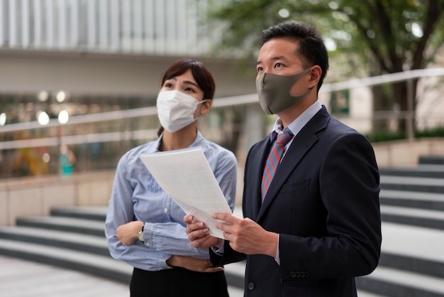 Vista frontale dell'uomo e della donna che indossa la maschera per il viso