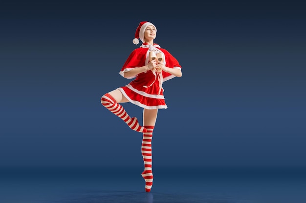 Ballerina danzante con un regalo in mano sulle scarpe da punta in costume di Babbo Natale su uno sfondo blu scuro