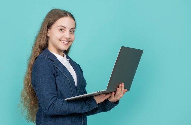 Bambino positivo con il computer su sfondo blu