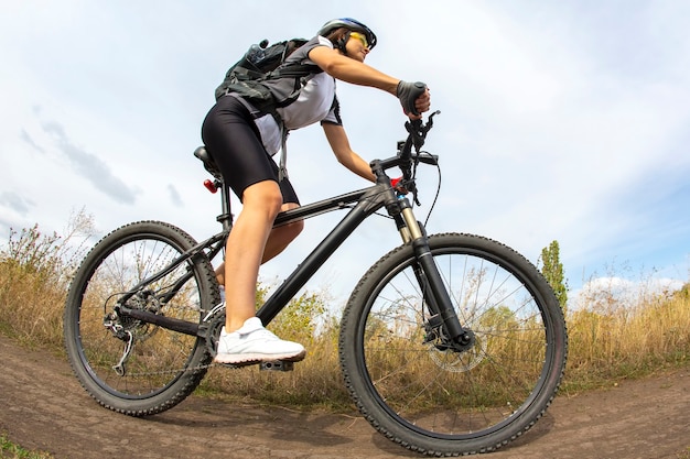 Bella donna ciclista con una bicicletta sulla natura