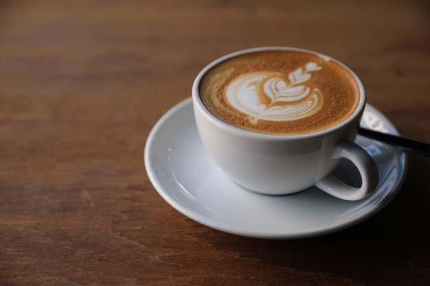 Cappuccino o Latte art caffè a base di latte sul tavolo di legno nella caffetteria