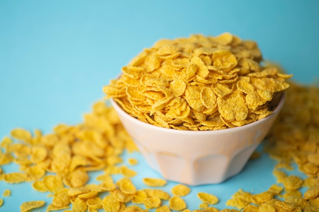 Cereali per la colazione in una ciotola rosa su sfondo blu.