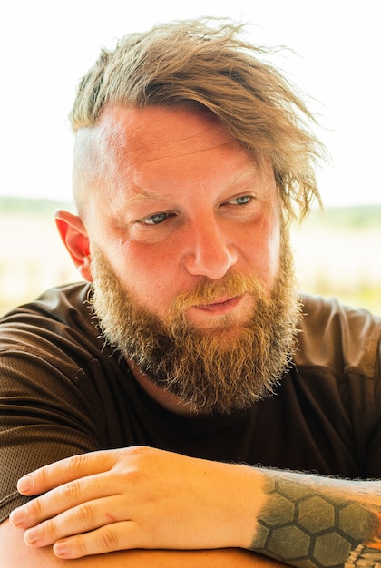 Foto chiuda sul ritratto dell'uomo alla moda hipster rossa con barba sfocata