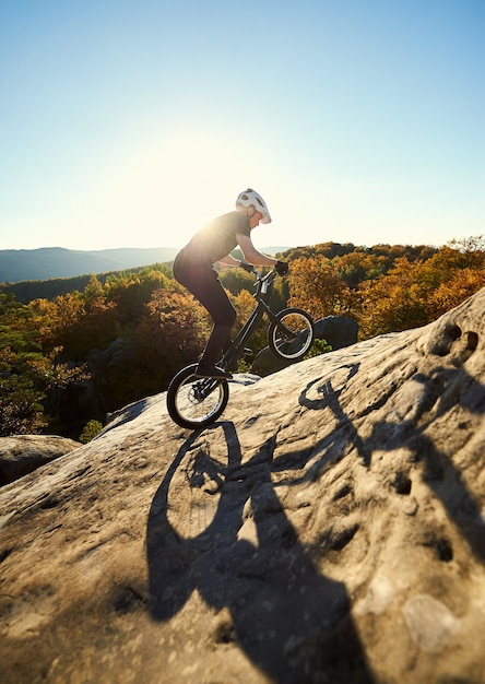 Foto ciclista professionista in equilibrio sulla bicicletta di prova al tramonto