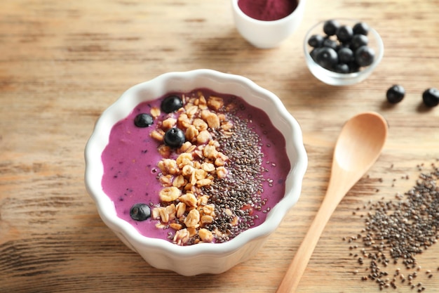 Ciotola con muesli frullato di acai e semi di chia su fondo di legno