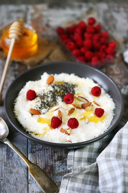 Ciotola per la colazione con lamponi, miele e semi.