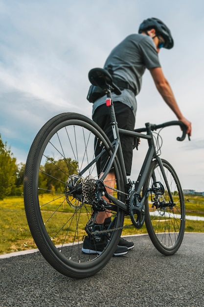 Colpo verticale del ciclista con una bici da strada sulla pista ciclabile.