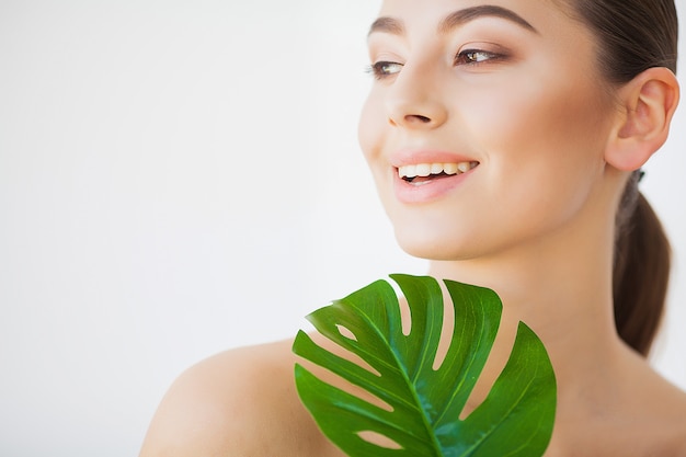 Cure termali. Giovane donna graziosa del brunette con il grande foglio verde