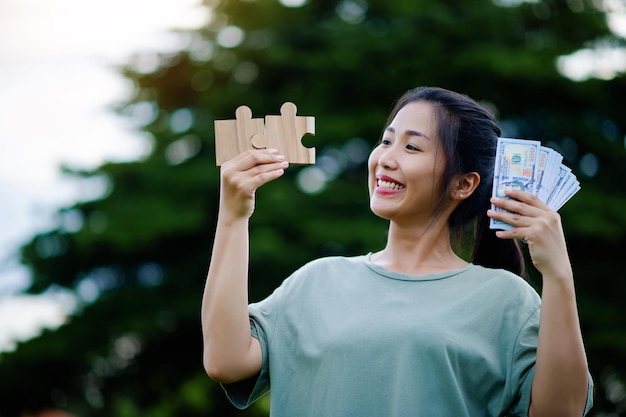 Foto dollaro nelle mani di una donna asiatica risparmio investimenti stipendio reddito flusso di cassa felicità, successo finanziario e investimenti