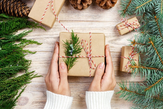 Donna che avvolge i regali di Natale moderni a casa