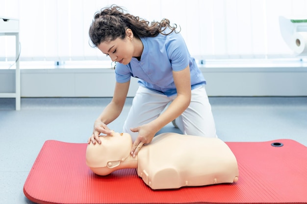 Donna che pratica tecnica cpr su manichino durante la formazione di primo soccorso Addestramento di primo soccorso Rianimazione cardiopolmonare Corso di pronto soccorso su manichino cpr