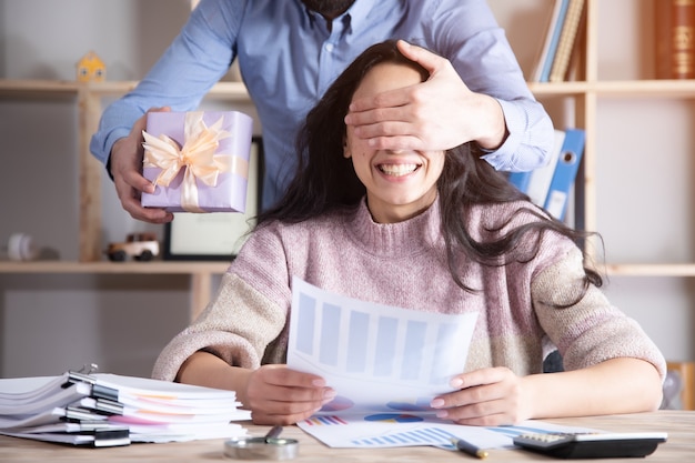 Foto donna felice con scatola regalo azienda uomo in ufficio