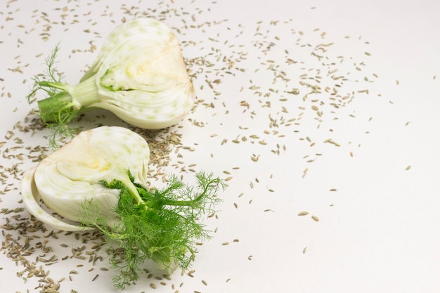 Foto due metà del bulbo di finocchio, semi di finocchio sul tavolo. cibo salutare