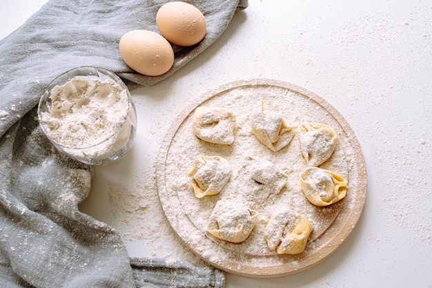 Fare i tortellini in casa, fatti a mano, sul piano di lavoro della cucina