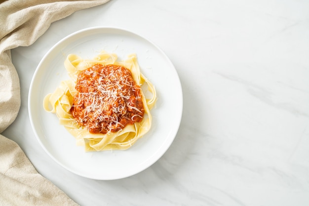 Foto fettuccine alla bolognese di maiale con parmigiano - italian food style