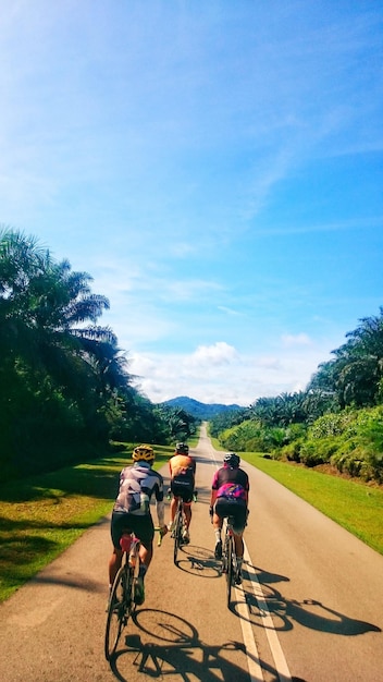 Foto gente in bicicletta sulla strada contro il cielo