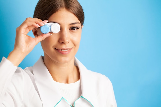 Giovane donna che tiene un contenitore bianco con lenti