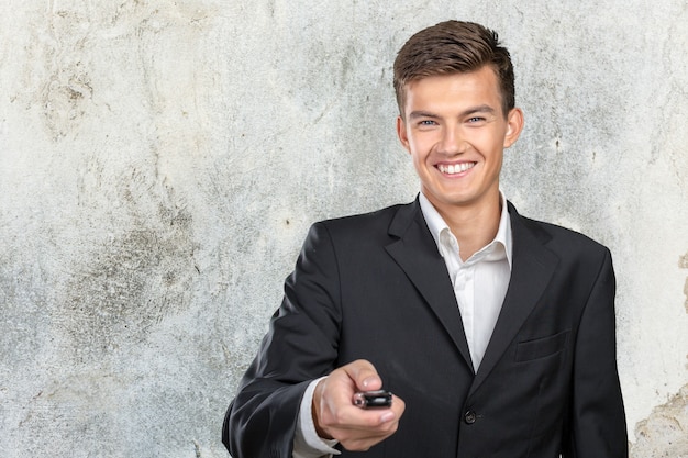 Giovane uomo sorridente che tiene le chiavi della macchina