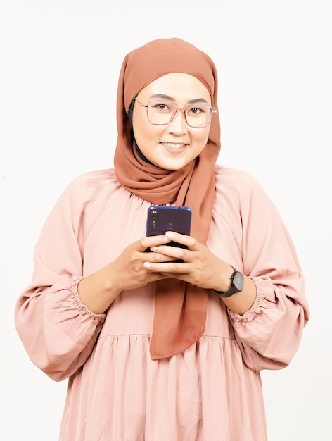 Holding Smartphone di bella donna asiatica che indossa Hijab isolato su sfondo bianco