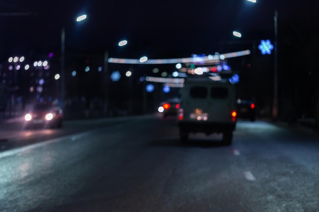 Immagine sfocata della vista del traffico automobilistico notturno dalla strada Sfondo scuro della vita notturna colorata