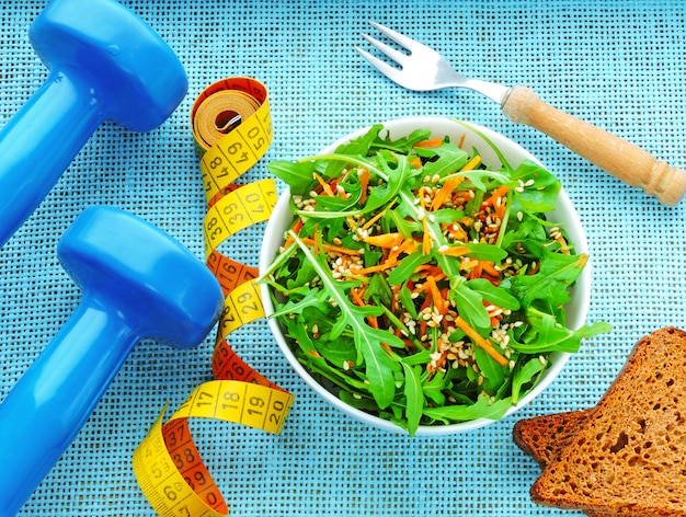 Insalata di fitness deliziosa e nutriente con rucola carote e sesamo. Il concetto di perdita di peso e stile di vita sportivo