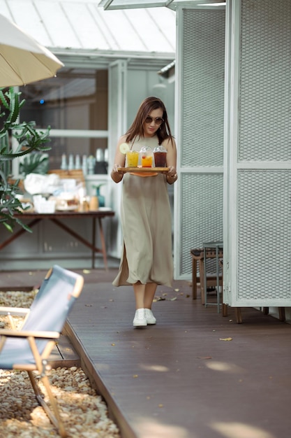 Le donne asiatiche in abiti lunghi servono caffè e succhi di frutta nella caffetteria