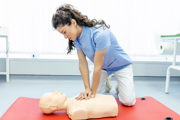 Lezione di RCP con istruttori che parlano e dimostrano le compressioni di pronto soccorso e la procedura di rianimazione Manichino RCP