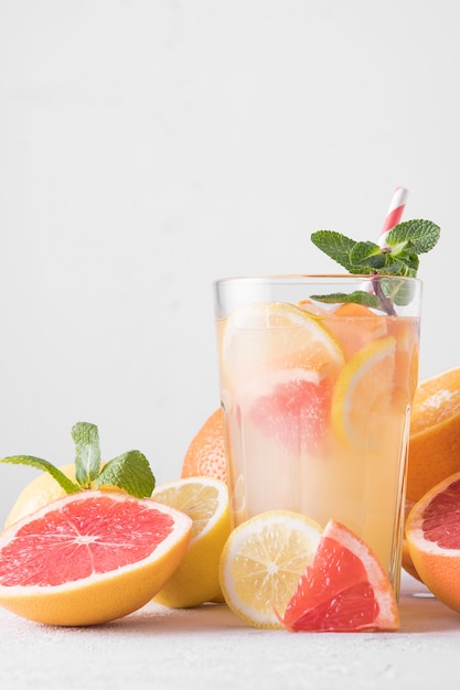 Limonata rinfrescante di estate con la menta su uno sfondo chiaro.