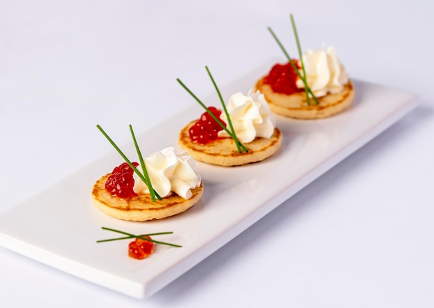 Macro fotografia alimentare di antipasto con caviale ed erba cipollina