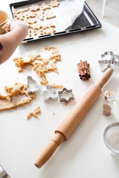 Mani della donna che cuociono i biscotti in cucina