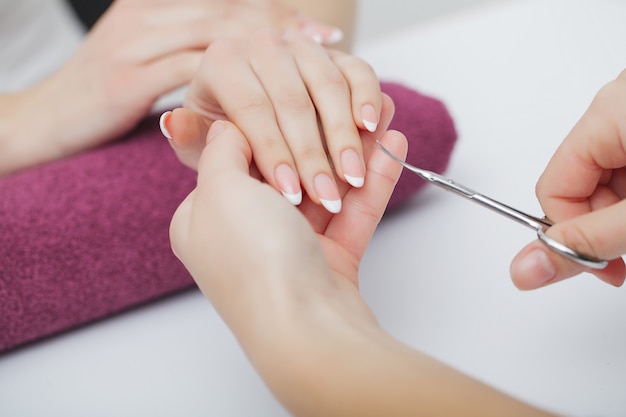 Mani di donna in un salone per unghie che ricevono una procedura di manicure