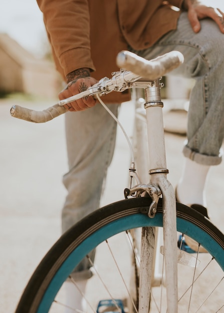 Foto mano tatuata che tiene sul primo piano del manubrio della bici