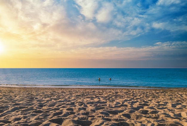 Paesaggio della spiaggia al tramonto con drammatico cielo nuvoloso